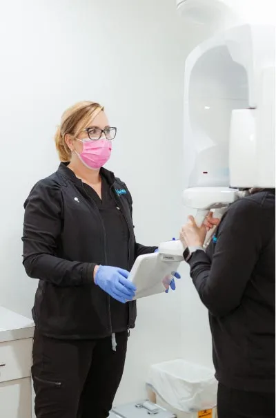 dental assistant taking a patient's x-rays before an emergency dental procedure