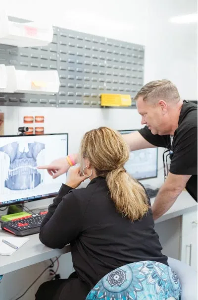 Dr. Anderson and dental assistant going over a patient's 3d scan of their mouth